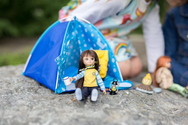 Lottie doll drinking coffee outside the tent