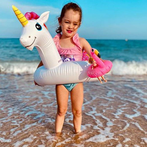 Girl holding lottie doll with inflatable flamingo floaties