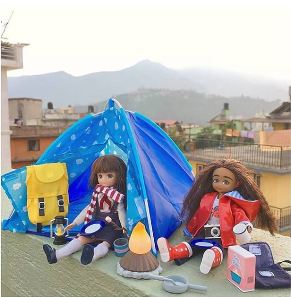 two lottie dolls sitting outside tent