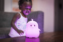 Girl looking at the White lumipet Penguin with remote as it is lit pu light purple