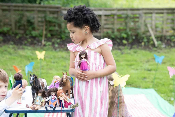 Girl playing withLottie Ballet Doll with brunette hair