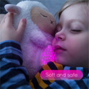 Child hugging the White Lamb with star and moon projection lights on tummy.