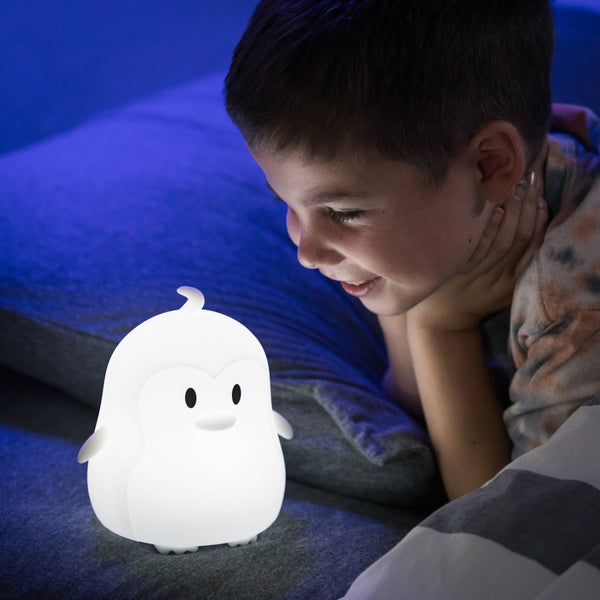 Boy looking at White lumipet Penguin with remote