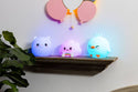 Soft White Chick with Remote lit with a blue soft light on a shelf with a Rainbow LumiPet and Piggy Lumipet
