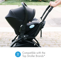 Mom pushing her baby in the liing infant carseat and stroller attachment