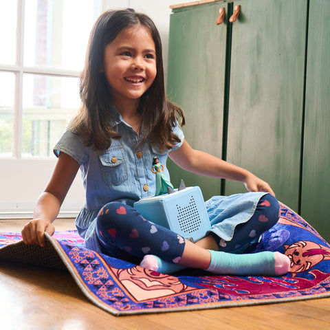 Girl on a magic carpet with her toniebox.