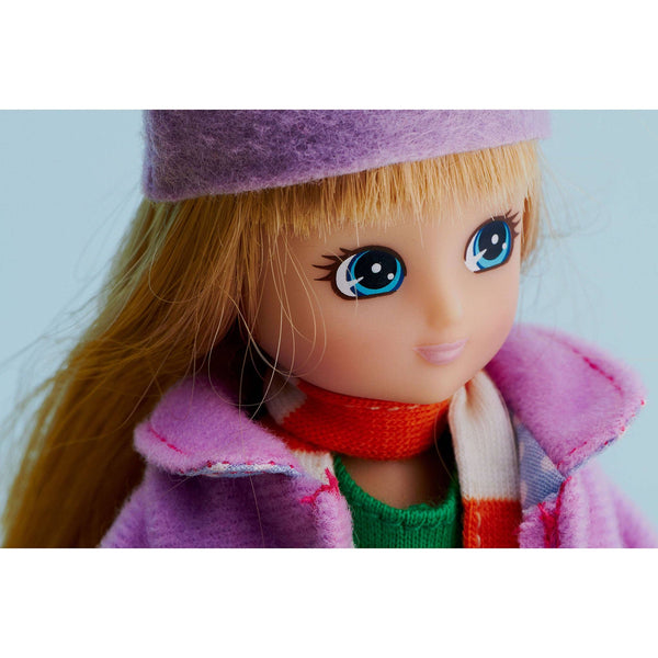 Doll wearing a duffel coat, scarf, hat, boots, corduroy skirt, and striped leggings