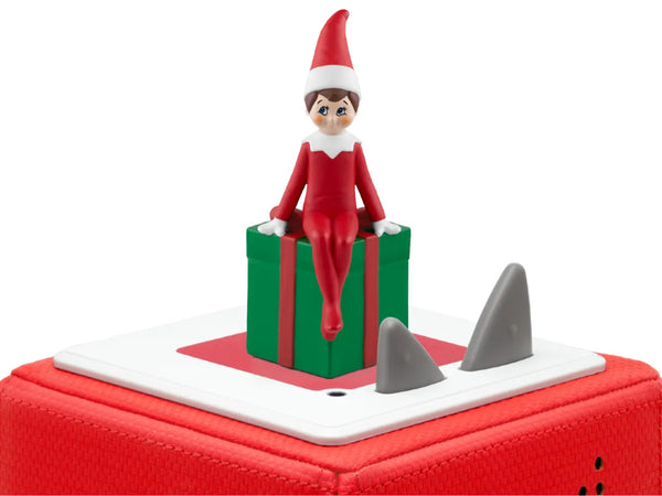 tonies elf on the shelf sitting on a green present